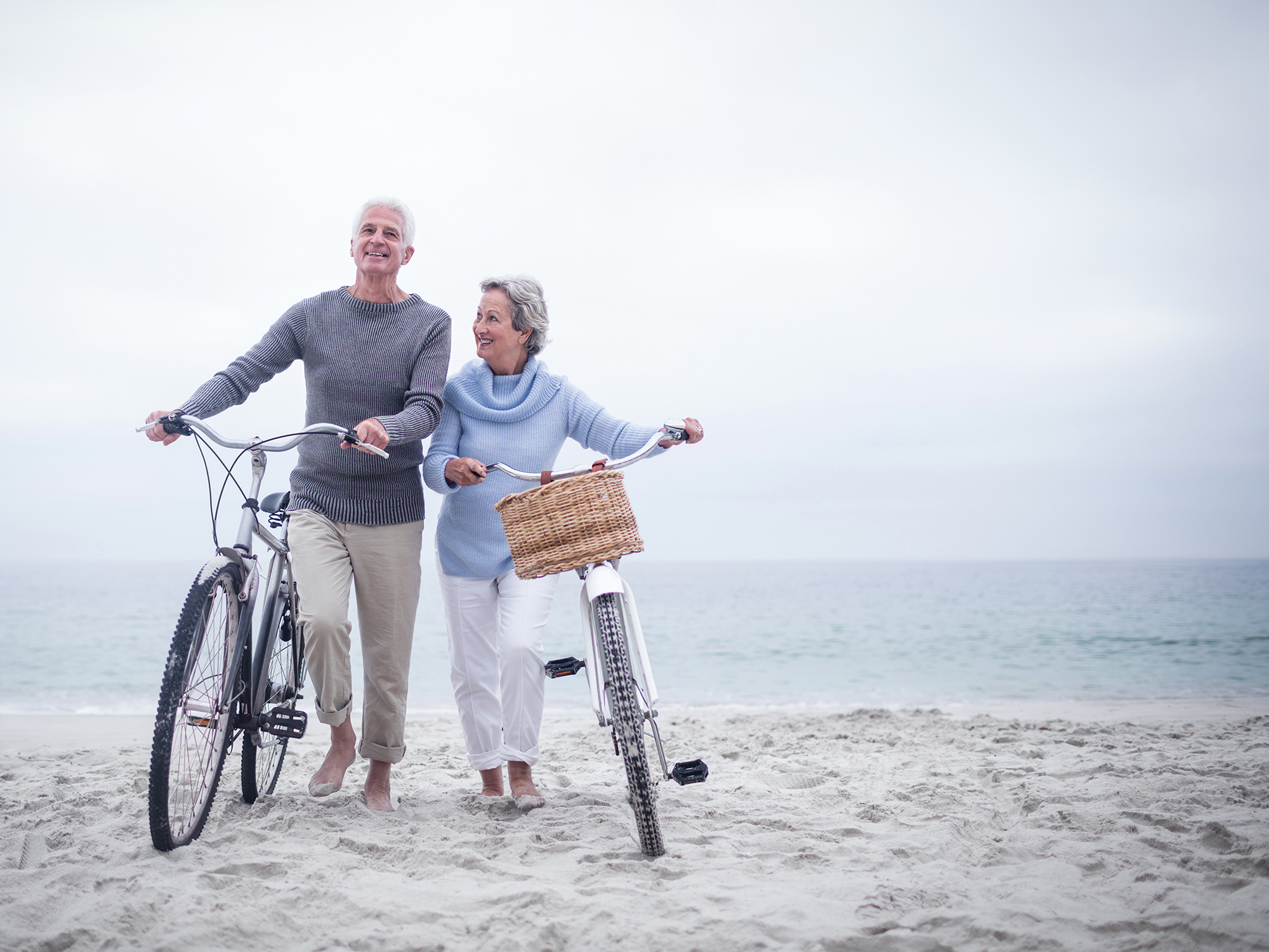 Senior couple on a beach with bicycles