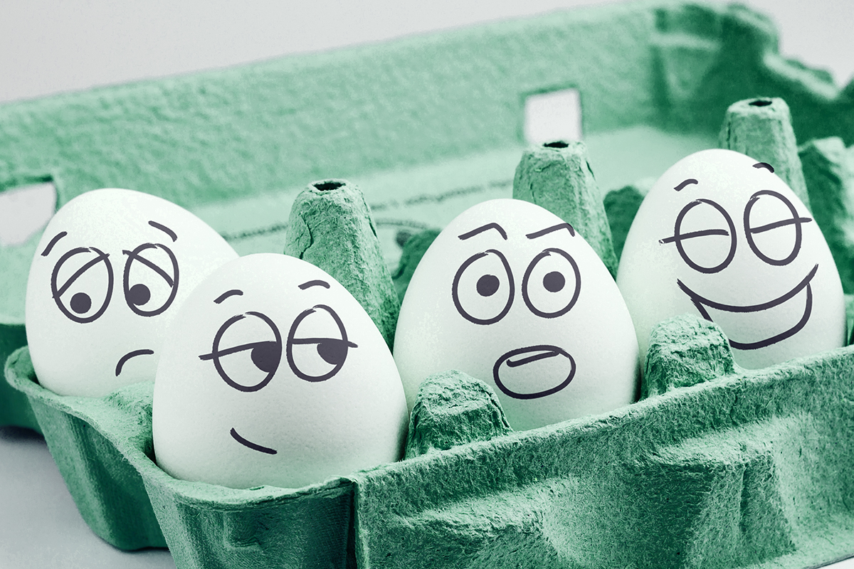 Carton of eggs with various faces drawn on them