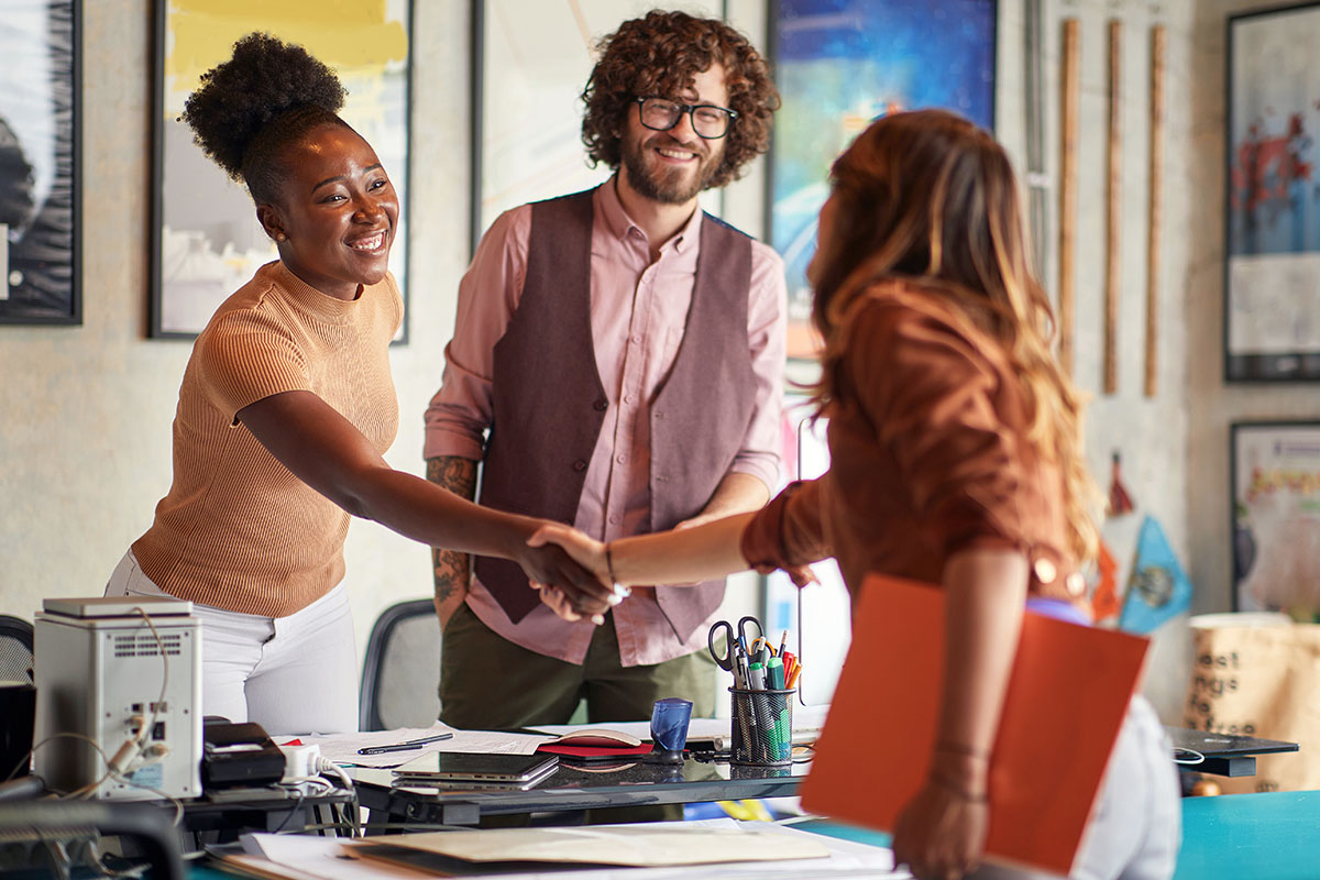 Three people shaking hands after a job interview