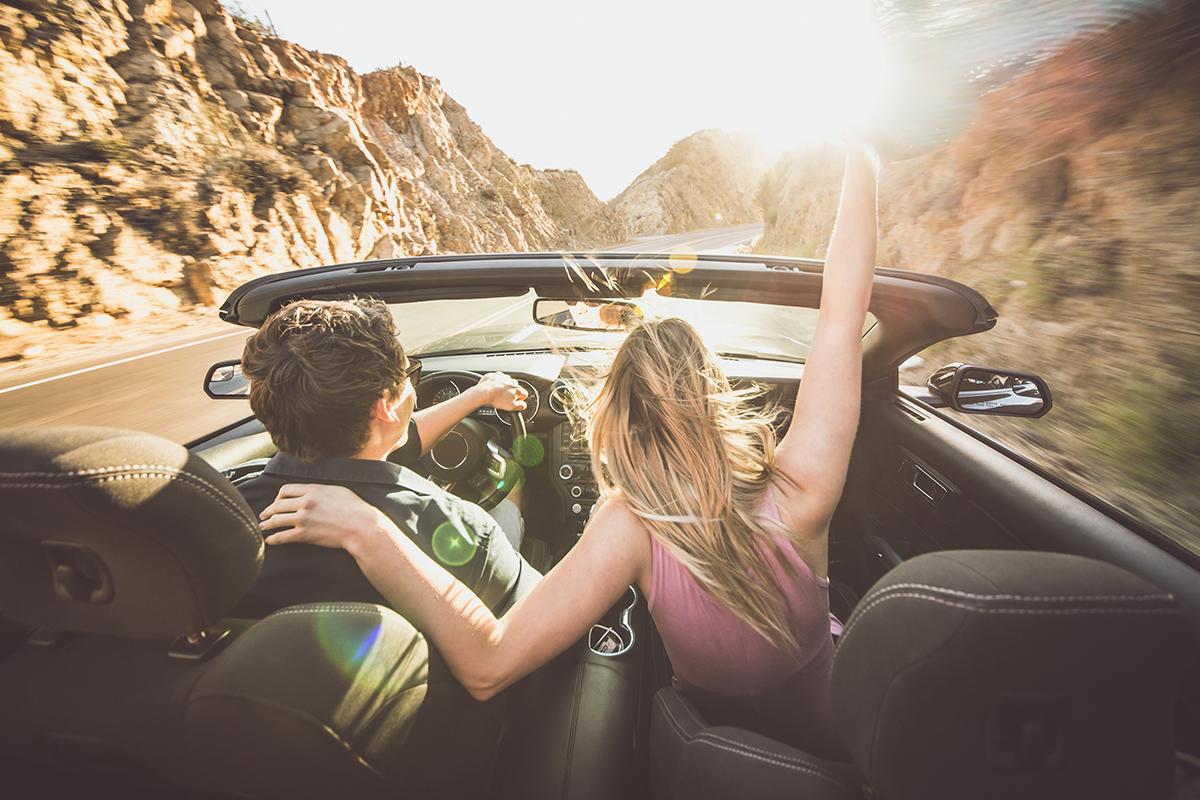 2 people traveling in a convertible