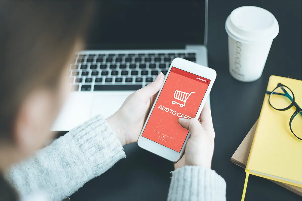 Hands holding a phone with Add to Cart on the screen