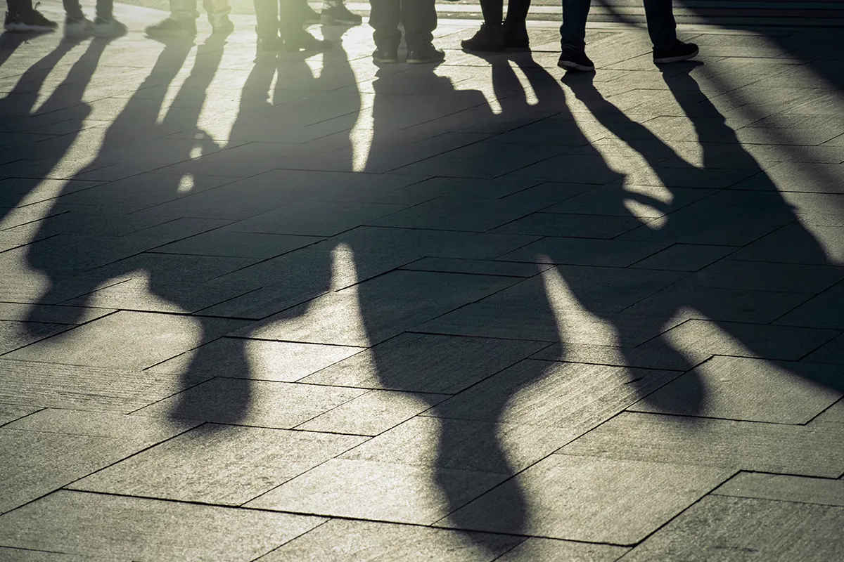 Shadows of people on a sidewalk