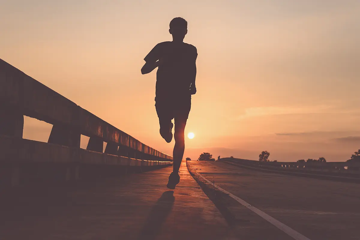 Person running along the road as the sun is setting