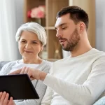 Adult helping a senior on their laptop